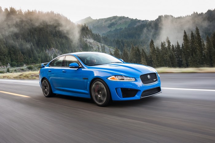 Blue 2014 Jaguar XFR-S driving on a mountain road