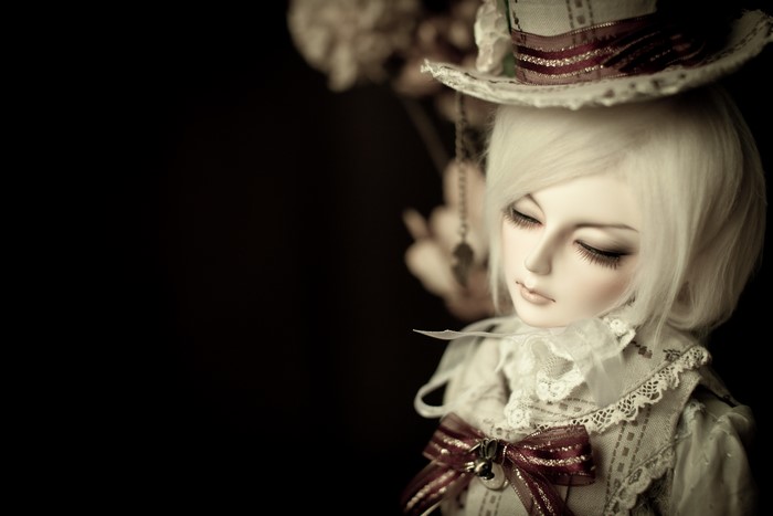 Doll wearing a hat and a bowknot