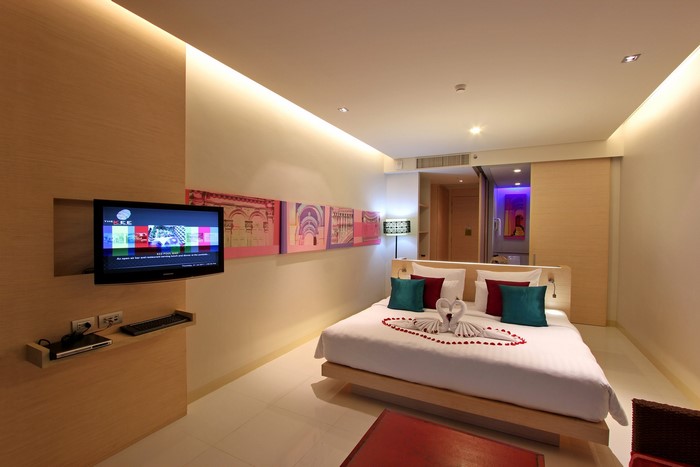 Modern hotel bedroom with TV and king-size bed