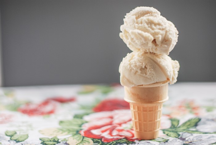 Two scoops of vanilla ice cream in a cone