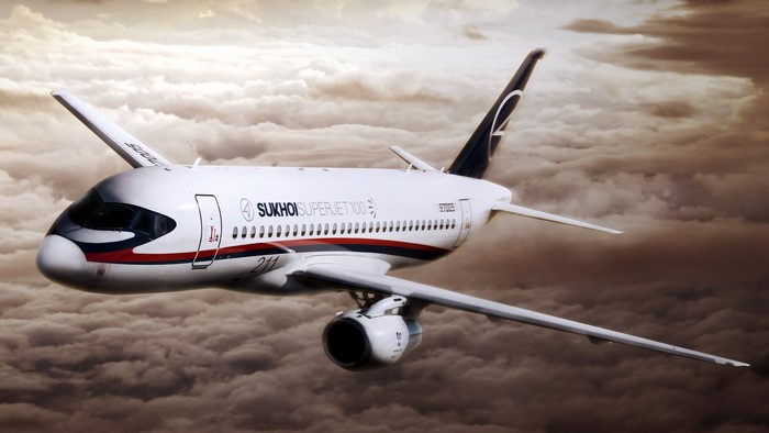 Sukhoi Superjet 100 airplane flying through clouds