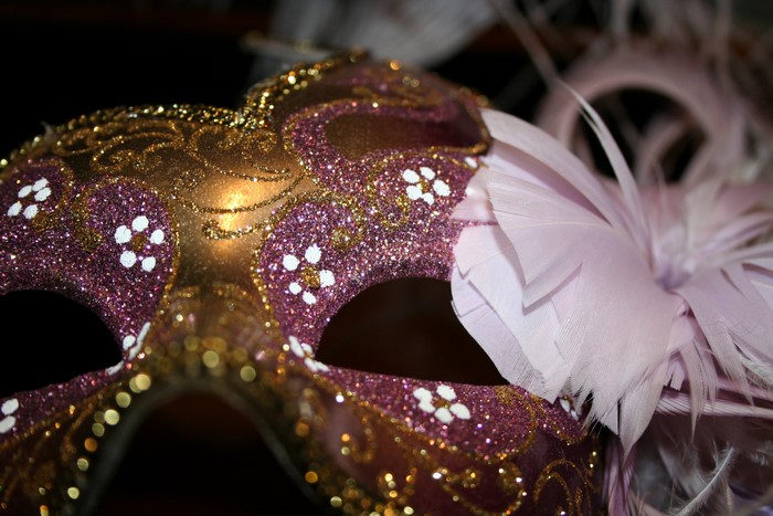 Close-up of a decorated masquerade mask with feathers