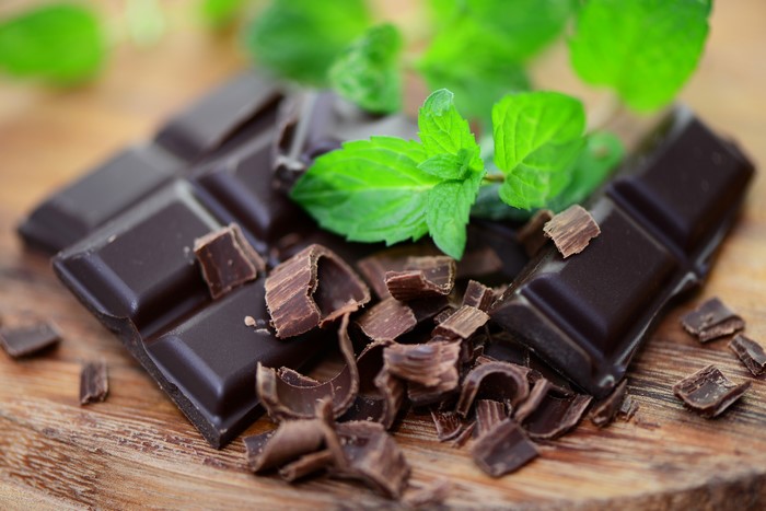 Dark chocolate bar with mint leaves and shavings