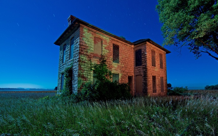 Abandoned stone house at night with starry sky