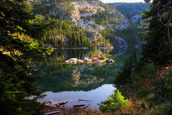 Lake with island and forested mountains in USA