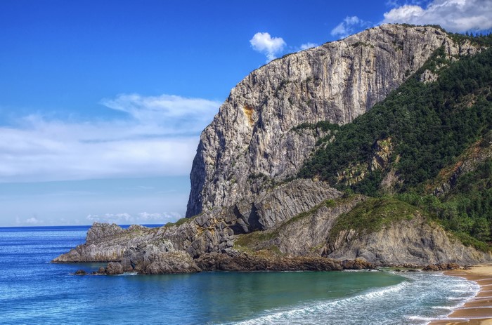 Rocky coast with a sandy beach and blue sea