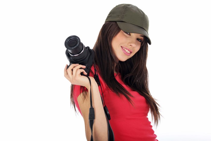 Brunette girl with camera wearing baseball cap