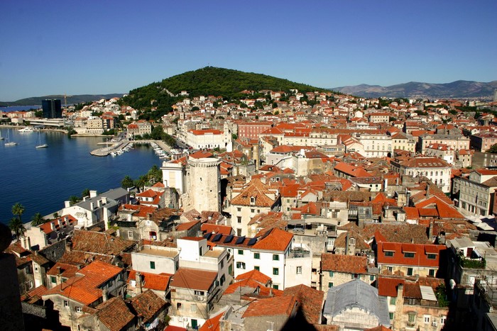 Cityscape of Split, Croatia with a harbor and green hill