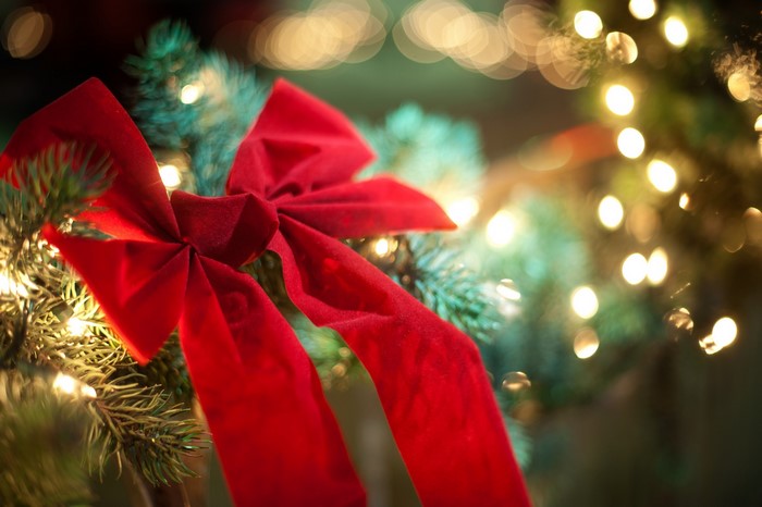 Red velvet bow on a Christmas tree with lights