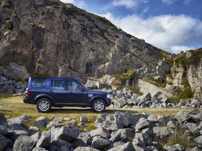 Blue Land Rover Discovery in a rocky mountain landscape