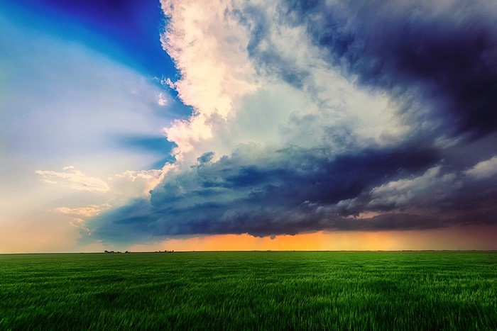 Green field under dramatic storm clouds