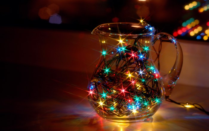 Glass jug filled with colorful Christmas fairy lights