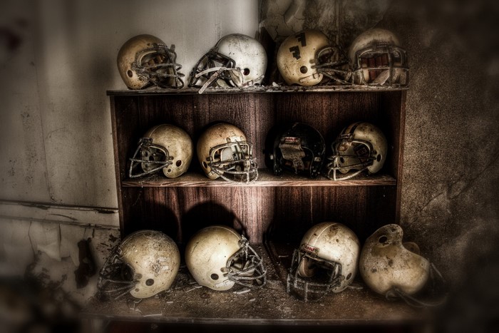 Collection of old American football helmets on shelves