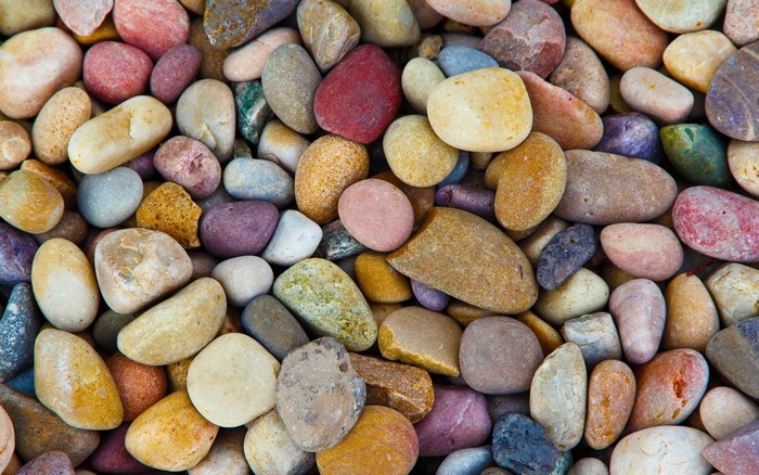 A close-up view of many colorful, smooth stones.
