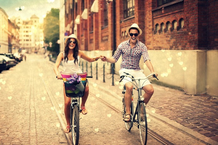 Couple riding bicycles on a cobblestone street