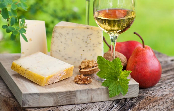 Still-life of cheese, nuts, pears, and white wine