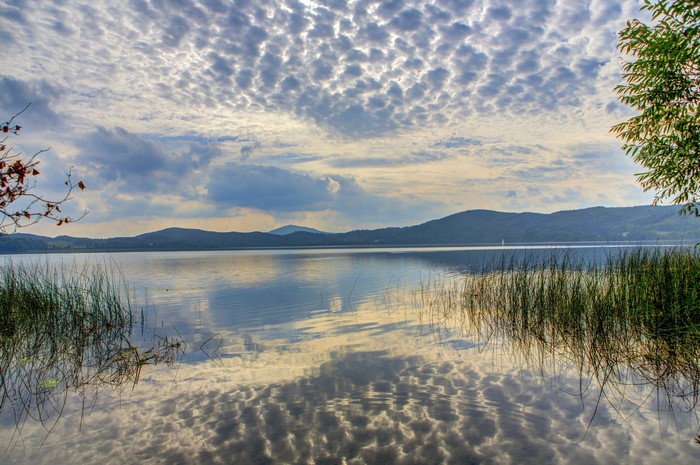 Lake with rolling hills and patterned clouds
