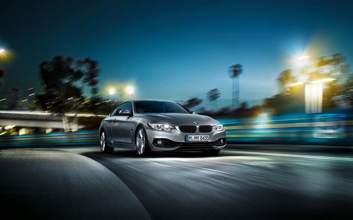Silver BMW 4 Series Coupe driving at night