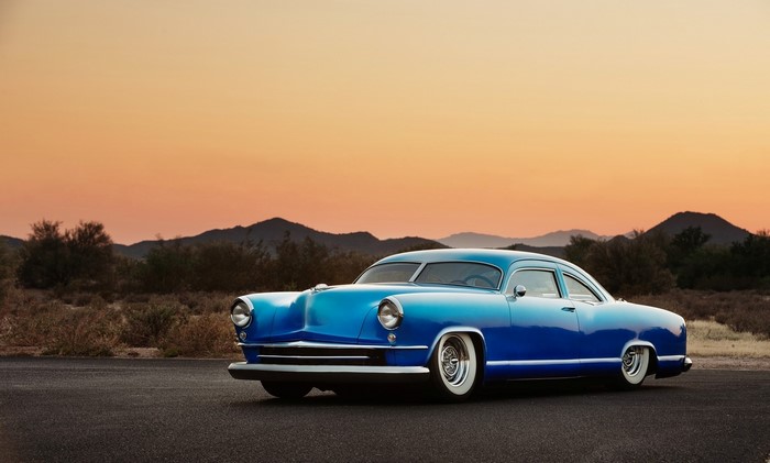 Blue Kaiser Racing car in desert landscape