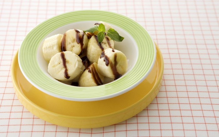 Sliced bananas with chocolate sauce on a plate