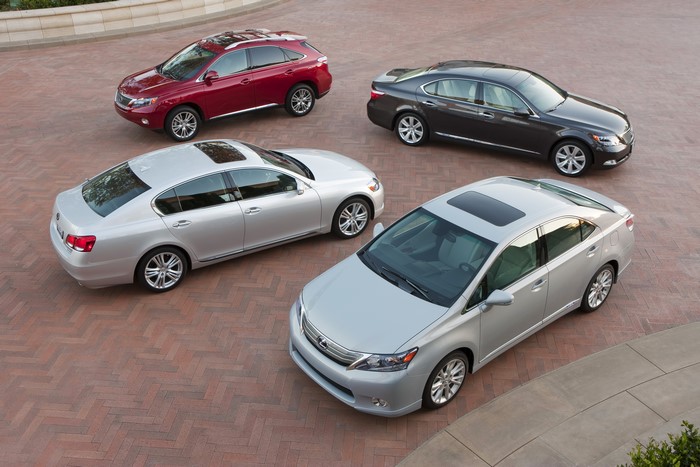Four Lexus cars parked on a brick driveway