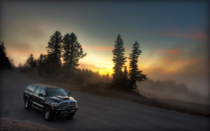 Black Dodge Truck on a Foggy Mountain Road at Sunset