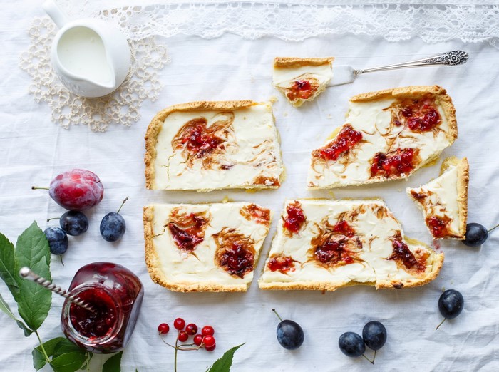 Plum cheesecake tart slices with jam and fresh plums
