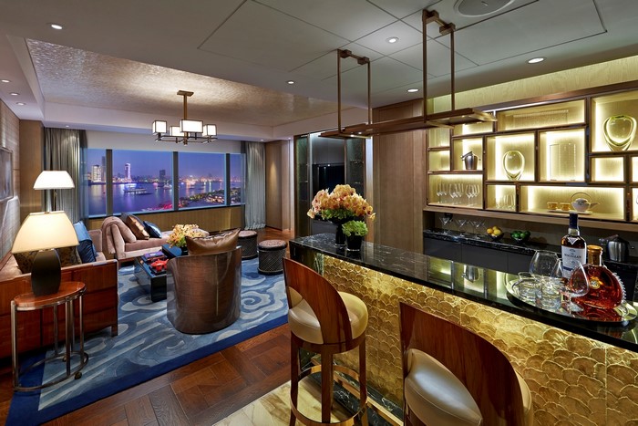 Luxury hotel suite living room with bar and city view