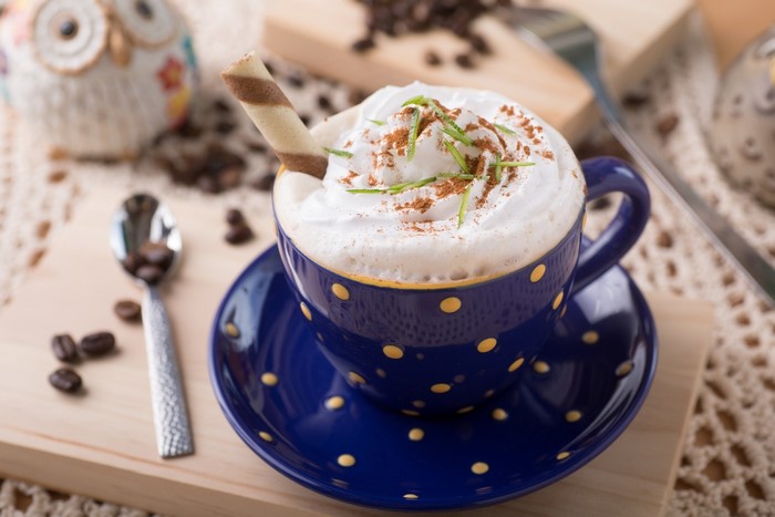 Coffee with whipped cream and a wafer stick
