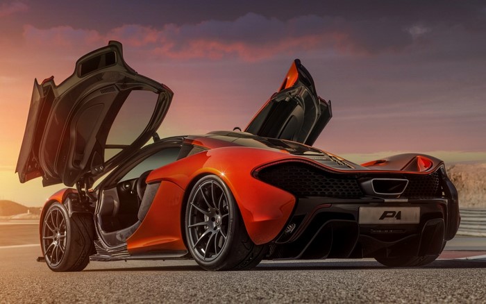 Orange McLaren P1 with doors open at sunset