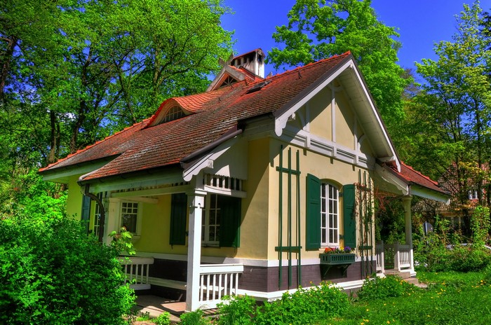 Yellow house with green shutters in a forest, Germany