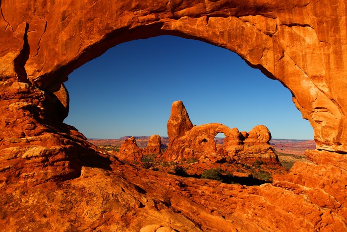 Natural rock arch framing desert landscape with rock formations