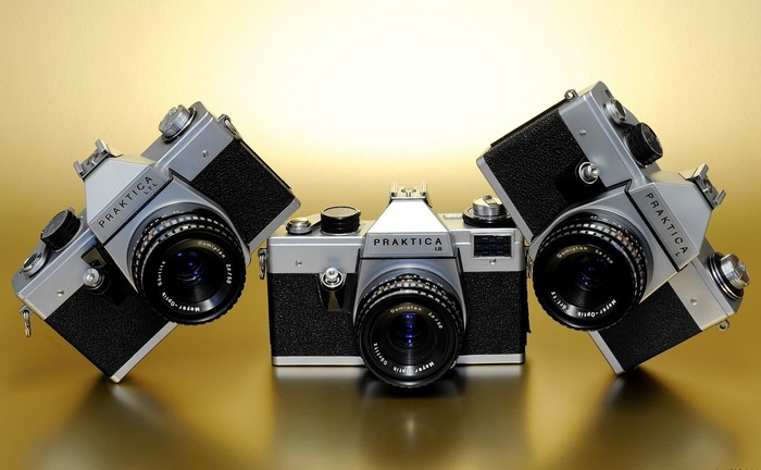 Three Praktica LTL LB L cameras on a gold surface