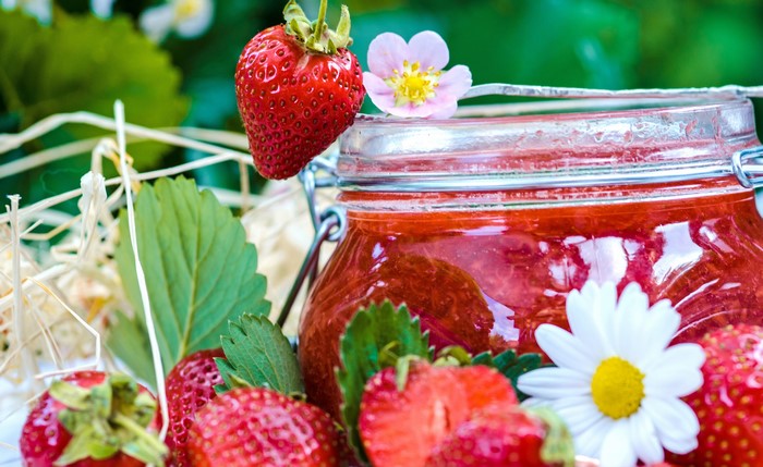 Strawberry Jam in a Jar with Fresh Strawberries and Flowers