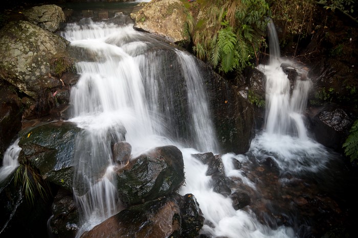 Waterfalls cascading over dark stones