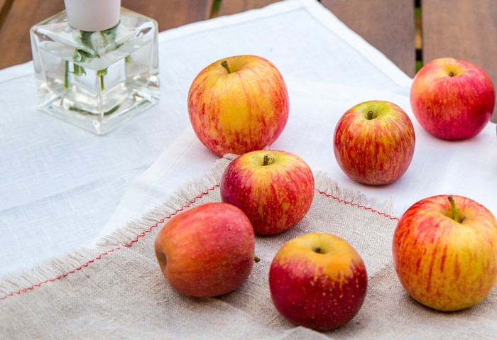 Apples on a table with a vase