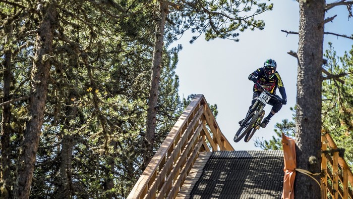 Mountain biker jumping off a wooden ramp