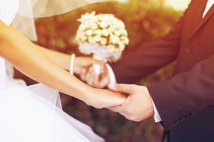 Bride and Groom Holding Hands with Bouquet