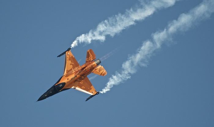 F-16 Fighting Falcon performing aerobatics with smoke trails