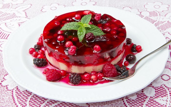 Berry jelly cake with mint on a plate with a fork
