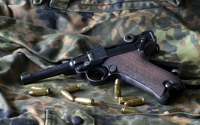 Luger P08 pistol with cartridges on camouflage fabric
