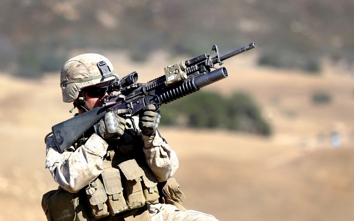 Soldier aiming an assault rifle with grenade launcher