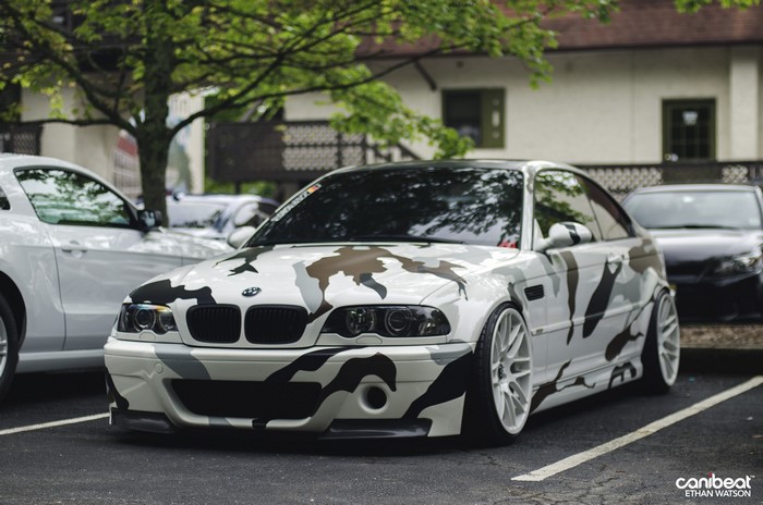 BMW M3 with camouflage wrap parked outdoors