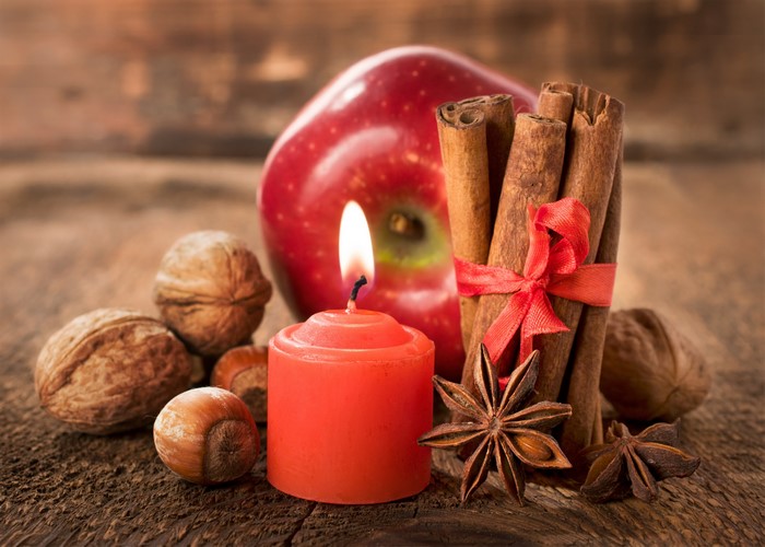 Apple, Cinnamon, Candle, Nuts, and Star Anise on Wood