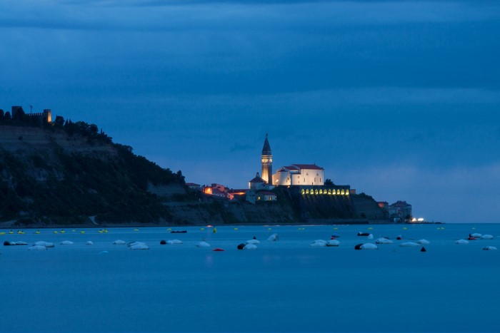 Coastal town with church and castle at dusk