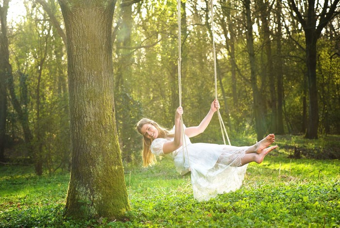 Woman on a swing in a forest