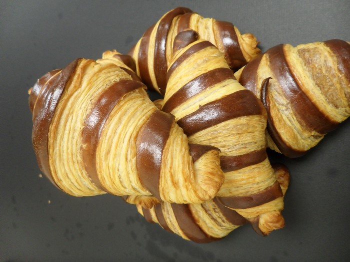 Chocolate striped croissants on a dark surface