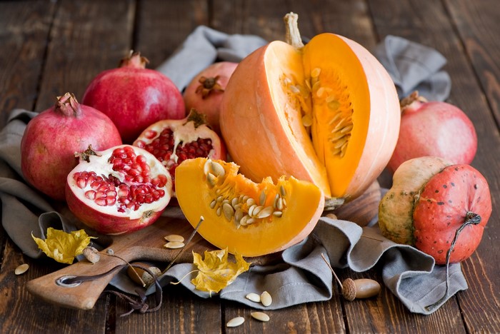 Pumpkins and pomegranates on a wooden table