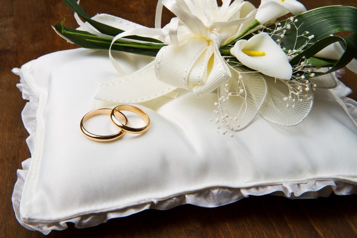Wedding rings on a decorative pillow with flowers