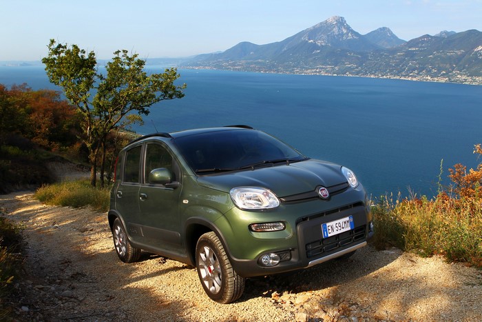 Green Fiat Panda 4x4 on a dirt road overlooking a lake